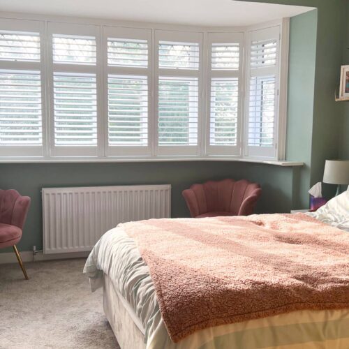 Full height shutters in a bedroom bay window